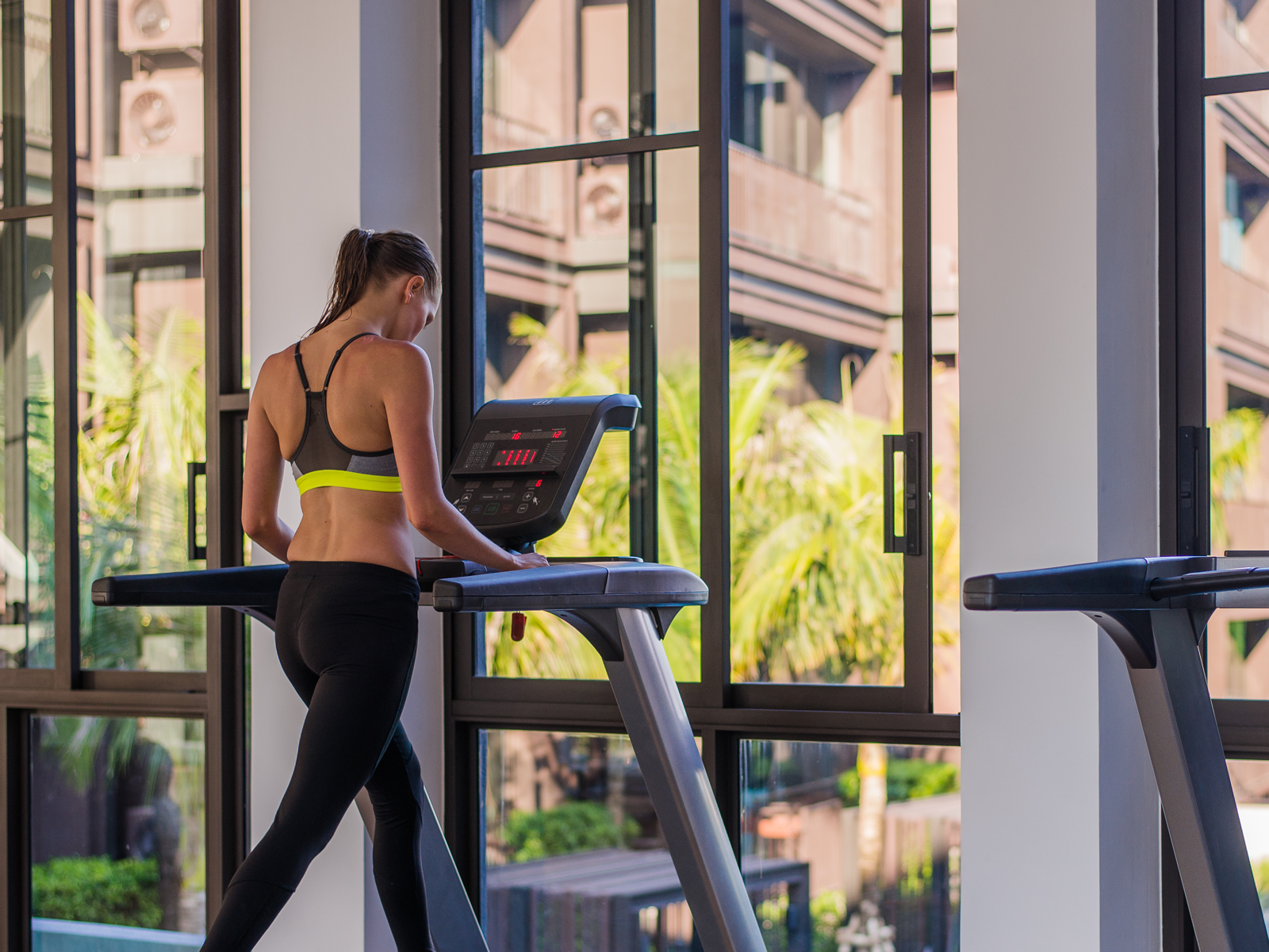 Femme s'entraînant sur tapis roulant dans une salle de fitness moderne